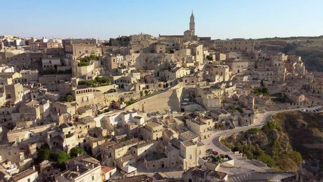 Aerial footage of Sassi di Matera in Basilicata, South Italy.Drone view of Sasso Caveoso and Civita districts, old city houses carved in rock caves, bell tower of Cathedral, Unesco heritage from above
