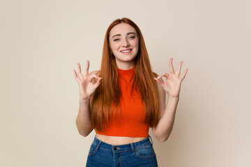 Young red hair woman isolated cheerful and confident showing ok gesture.