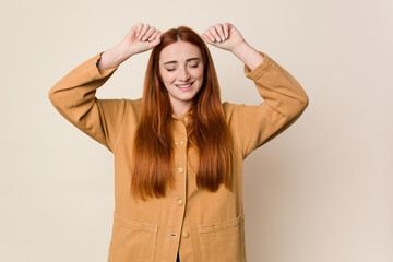 Fototapeta premium Young red hair woman isolated celebrating a special day, jumps and raise arms with energy.