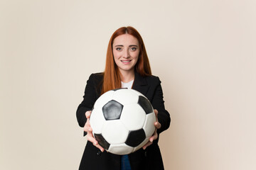 Young soccer trainer woman holding a soccer ball isolated