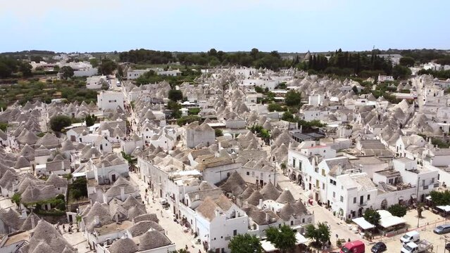 Aerial drone footage of Alberobello, Puglia, Italy. Establish scene of main streets, traditional whitewashed, conical roof (trulli) UNESCO world heritage site, landmark tourist destination from above