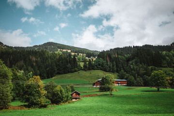 Majestic mountains in the Alps covered with trees and clouds