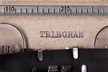 The word 'TELEGRAM' embossed on gray paper using an old typewriter.	
