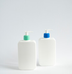 Two white blank plastic bottles with dispenser pump for gel, liquid soap, lotion, cream, shampoo on white background. Cosmetics.