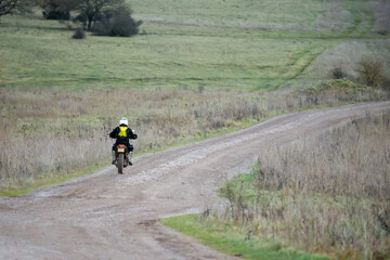a motor cyclist (biker) riding his off-road motorbike along a stone track on Salisbury Plain, Wiltshire