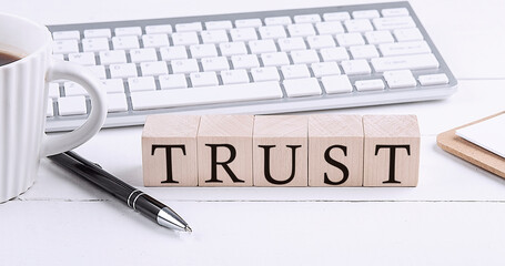 TRUST word on the wooden blocks with keyboard and coffee