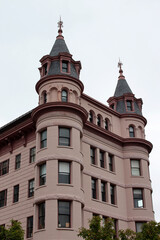Fototapeta na wymiar Edificio rosa con dos torreones redondos en las esquinas.