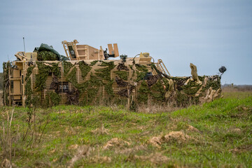 Fototapeta premium British army 6-wheel Mastiff Protected Patrol Vehicle with green camouflage netting in place