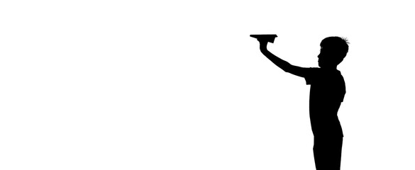 little kid holds origami of paper airplane in his hand and plays at sunset on the background of lake. A boy passionates about playing with his paper toy