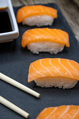 Salmon sushi with soy sauce on a slate base
