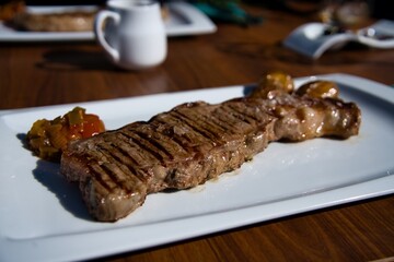 Grilled meat on white plate.