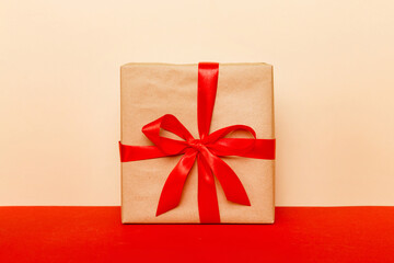 holiday brown paper present tied red ribbon bow top view with copy space. Flat lay holiday background. Birthday or christmas present. Christmas gift box concept with copy space