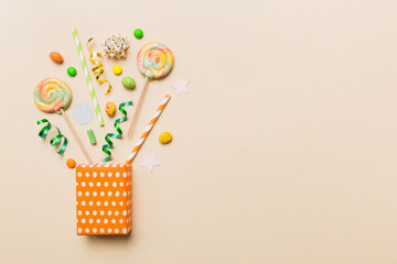 gift box in corner full of assorted traditional candies falling out on colored background with copy space. Happy Holidays sale concept