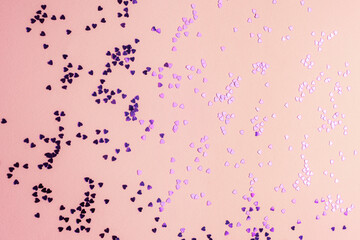 Purple heart shaped confetti on pink background