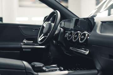 Modern sports car inside. Black interior with leather and plastic elements. Car cockpit cleaning process at car detailing studio. High quality photo