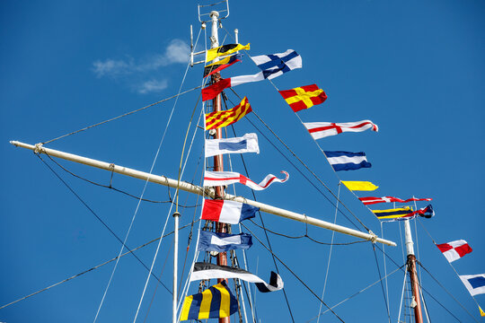 Nautical flags against blue sky.