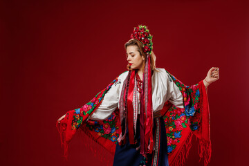 Portrait of ukrainian woman in traditional ethnic clothing and floral red wreath on viva magenta...