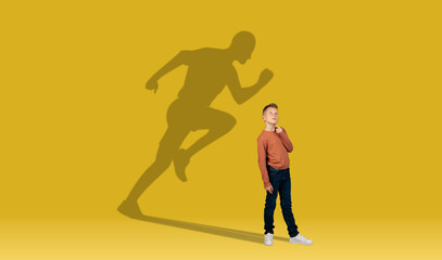 Boy and shadow of athletic runner on wall