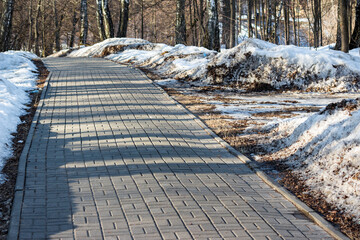 Pedestrian path paved with tiles and cleared of snow in winter