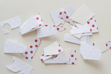 cut paper pieces (some with red polka dots) on blank paper