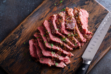 Corned beef cooked and sliced on a cutting board - obrazy, fototapety, plakaty