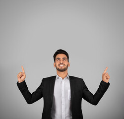 Check This. Smiling Young Arab Businessman Pointing Up At Copy Space