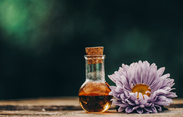 Oil bottle. Flowers. Oil. Glass. Background. 