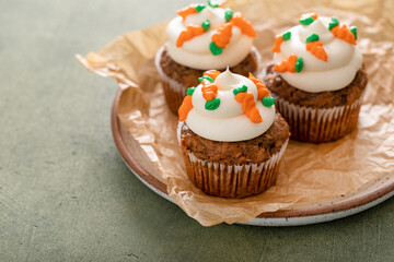 Carrot cupcakes with cream cheese frosting decorated with tiny carrots