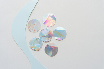 iridescent paper circles and wavy cut paper shape on blank paper