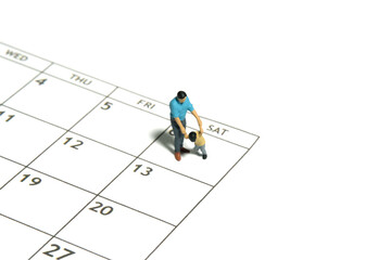 Miniature people toy figure photography. A father and son walking above calendar. Isolated white...
