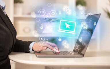 Hands working on laptop with digital icons