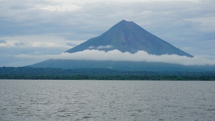 The symbol of Nicaragua - Concepción volcano, partially covered by a belt of clouds. Seen from Lake Nicaragua.