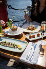 Woman eating Chilean Seabass dish on riverside during daytime