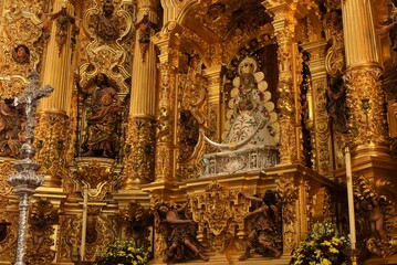 Finely dressed 17th century sculpture of the Virgin of El Rocío with Child in crowned ruling pose on a crescent symbolizing immaculate conception and victory at Lepanto, El Rocío, Spain