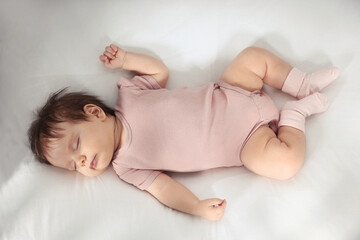 Cute little baby sleeping on cosy bed, top view