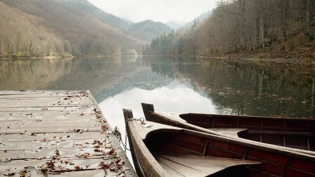 Old wooden bow of boat on the lake, reflection in the water. Slow motion shot 