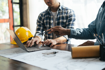 Close up view of Architect sketching a construction project on his plane project at site construction work. Architect working along side with engineers.