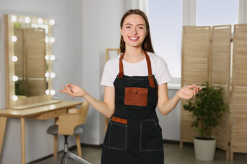 Portrait of professional hairdresser wearing apron in beauty salon