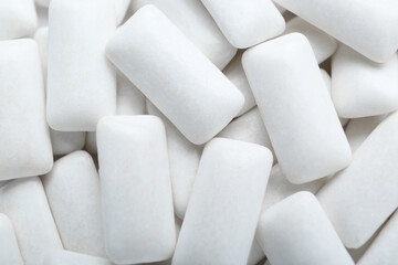 Tasty white chewing gums as background, top view