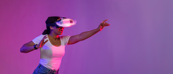 Happy Young Black Female Wearing Glowing VR Glasses Playing Video Games