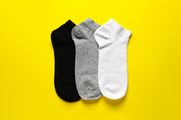 Different socks on yellow background, flat lay