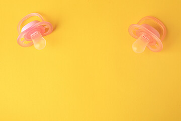 New baby pacifiers on orange background, flat lay. Space for text