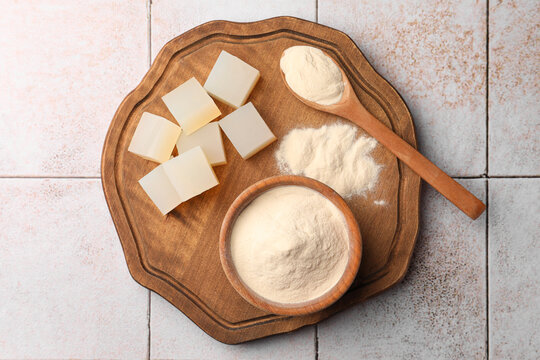 Agar-agar jelly cubes and powder on tiled surface, top view