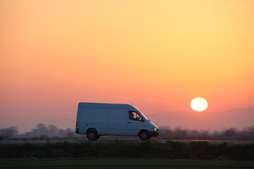 Small cargo van driving on highway hauling goods. Delivery transportation and logistics concept © bilanol