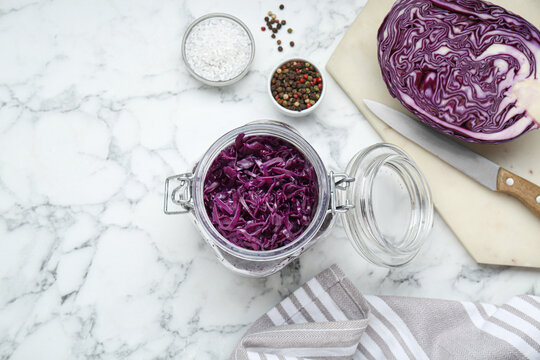 Tasty red cabbage sauerkraut and different ingredients on white marble table, flat lay. Space for text