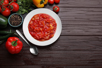 Delicious lecho and fresh ingredients on wooden table, flat lay. Space for text