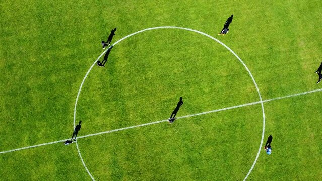 Vuelo de drone, sobre cancha de futbol con jugadores entrenando a pleno sol, al fondo un campo de agave.