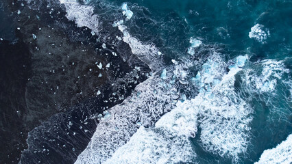 Melting Arctic Ice in Ocean Water, Blue Glacier Ice with Snow on Black Volcanic Beach in Iceland. Climate Crisis