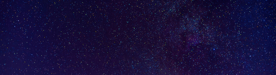 Astrophotography of a dark blue starry sky with many stars, nebulae and galaxies. Panoramic wide...