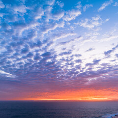 Naklejka na ściany i meble Sunrise sky over the sea with clouds and colour